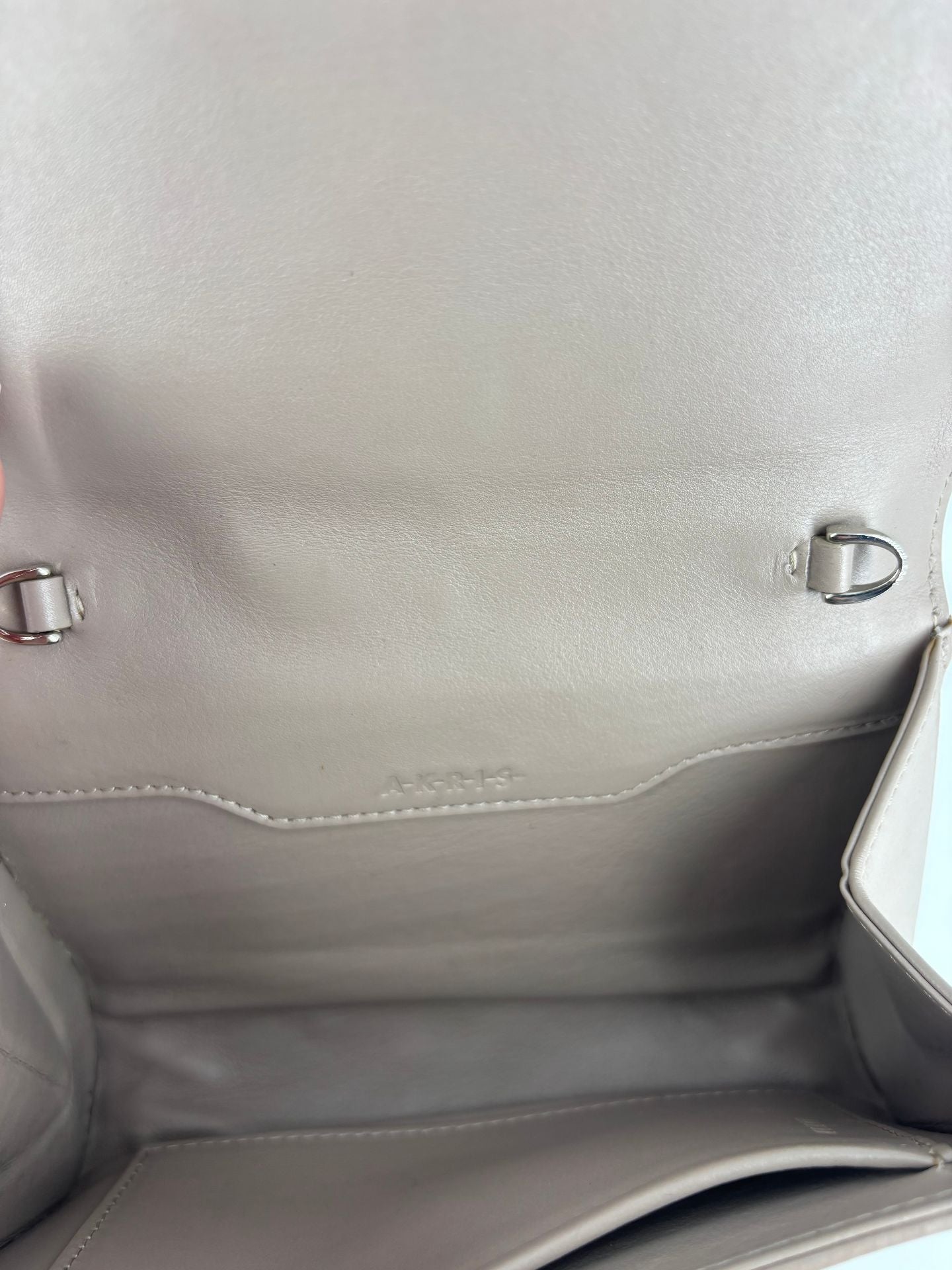 Pochette Akris cuir tressé taupe fermoir trapézoïdal argenté