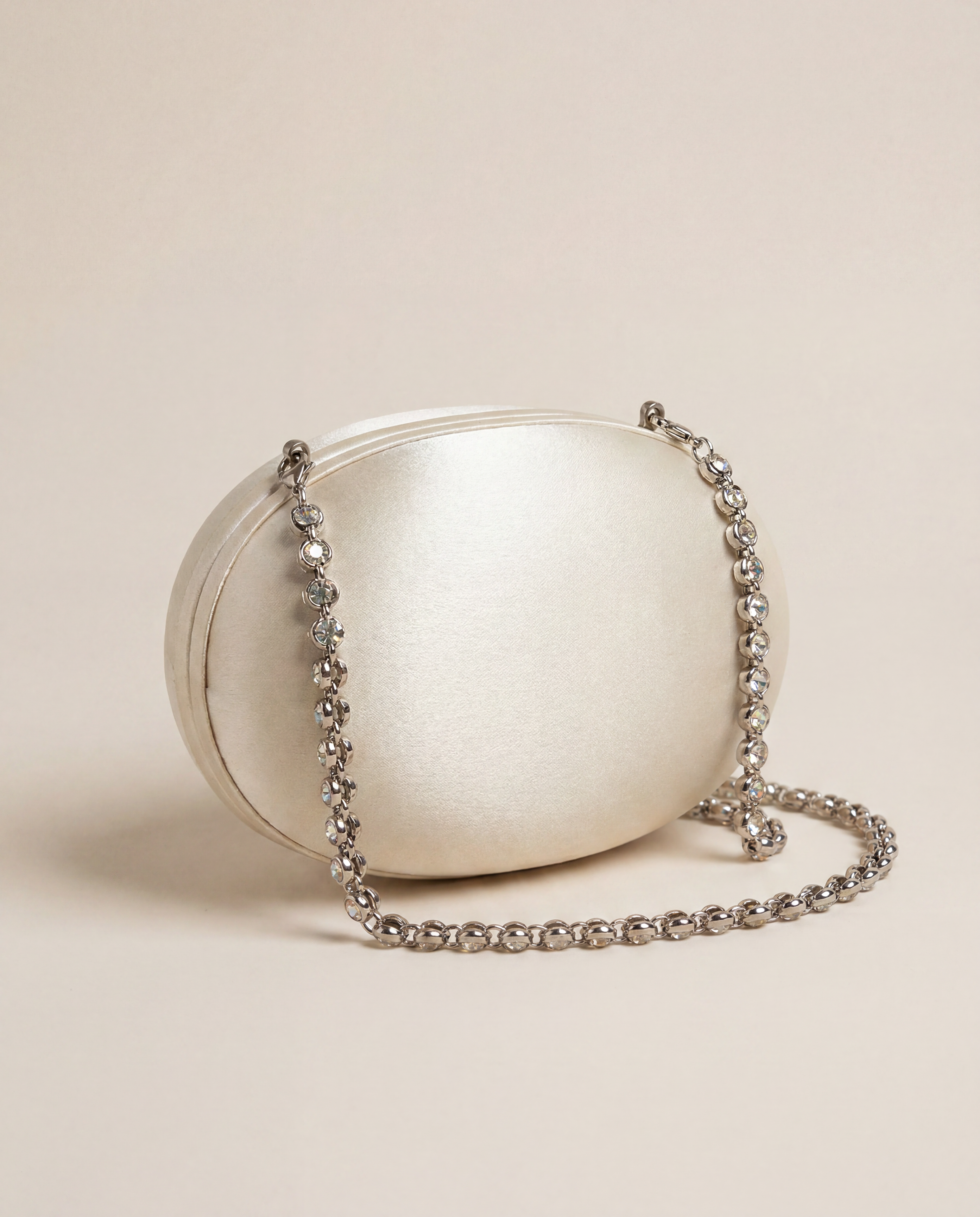 Pochette satin blanc cassé forme galet chaîne strass argentés – 8 × 12 cm

