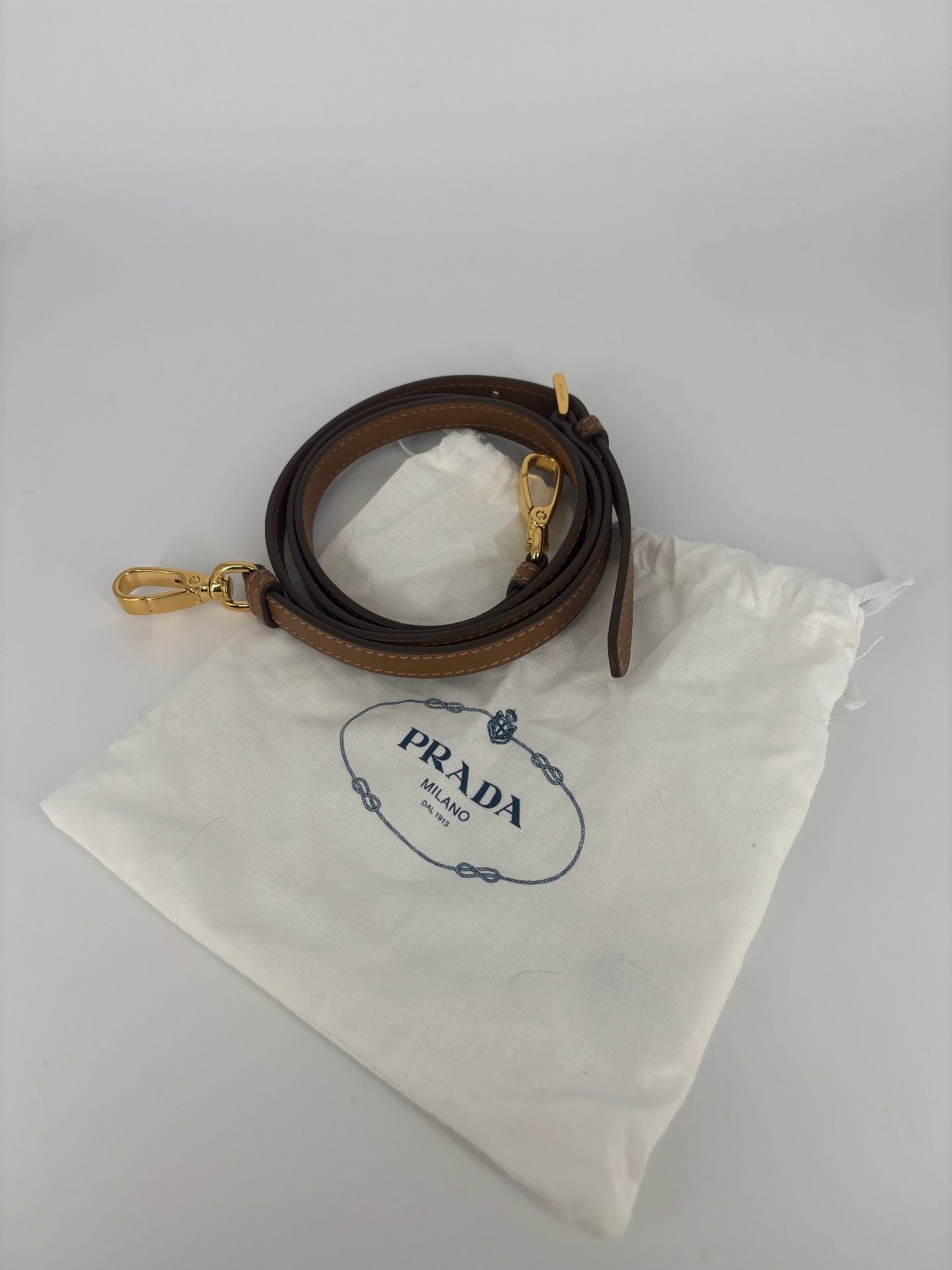 Bandoulière Prada cuir marron crochets dorés – 115 cm – étui d'origine