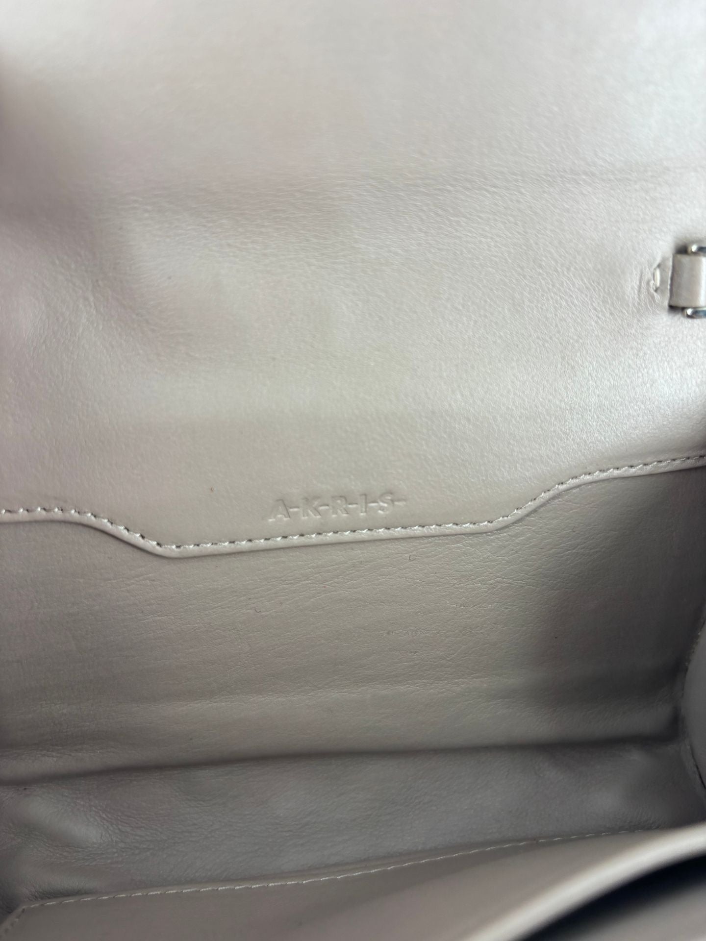 Pochette Akris cuir tressé taupe fermoir trapézoïdal argenté